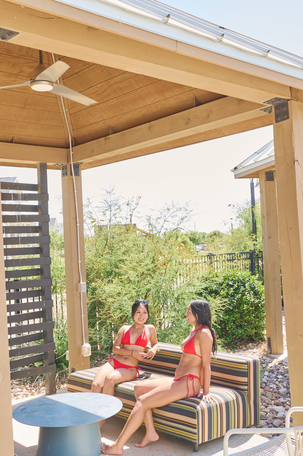 Two girls in red swimsuits sitting in a cabana