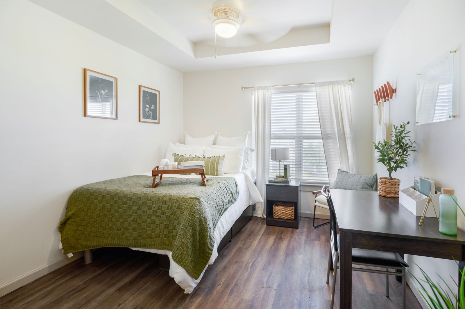 Bed with green blanket in bright bedroom