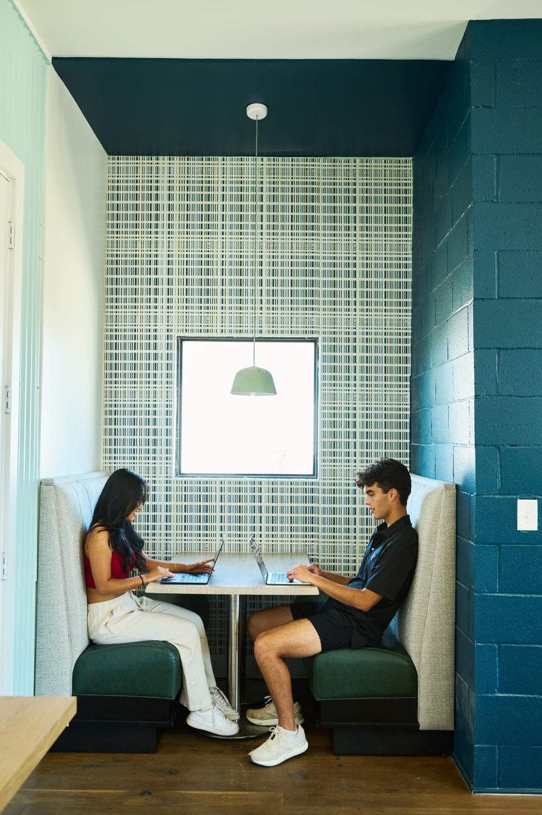 Two people at table on their laptops